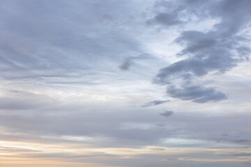 Moody Layers of Grey Clouds in Sky at Dusk with Soft Warm Orange Light Breaking near Horizon