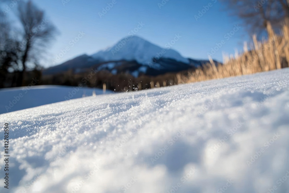Poster close-up of glittering snow with a mountain in the background under a blue sky. the scene showcases 