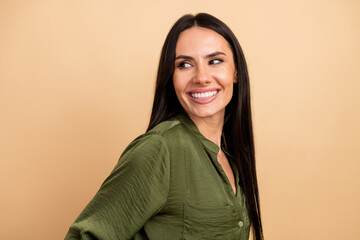 Portrait of a confident young businesswoman with a radiant smile in a green shirt, posing against a...