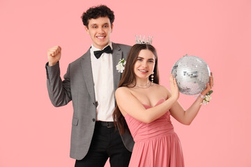 Pretty prom couple with disco ball on pink background