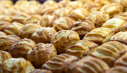 Puff pastries arranged in even rows, close-up