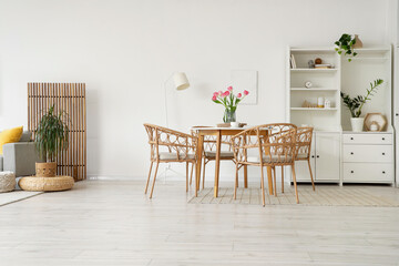 Interior of modern studio apartment with dining table, shelf unit and plants