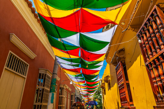 A view up a canopy covered backstreet in the Getsemani district of Cartagena, Columbia in springtime