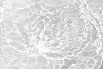 Fototapeta premium White water with ripples on the surface. Defocus blurred transparent white colored clear calm water surface texture with splashes and bubbles. Water waves with shining pattern texture background.