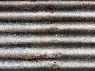 Close up of corroded corrugated iron sheet plate or called zinc plate. Commonly used for building construction and wall decoration. Industrial interior design vibes. Seamless background texture.
