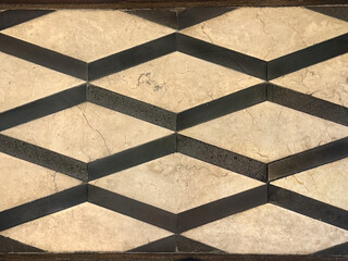 Diamond geometric yellow beige marble texture cut and arranged like a lattice or net pattern on a floor. Seamless marble flooring art, play with texture and pattern, no people.