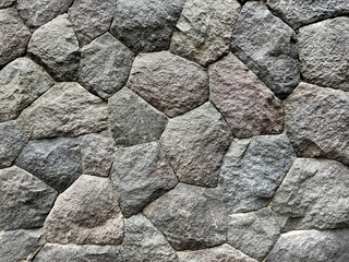 Natural random cut grey cobblestone cemented on a wall surface. Series of natural gravel or cobble stones exposed and weathered. Suitable for ancient building or dam. Seamless background texture.