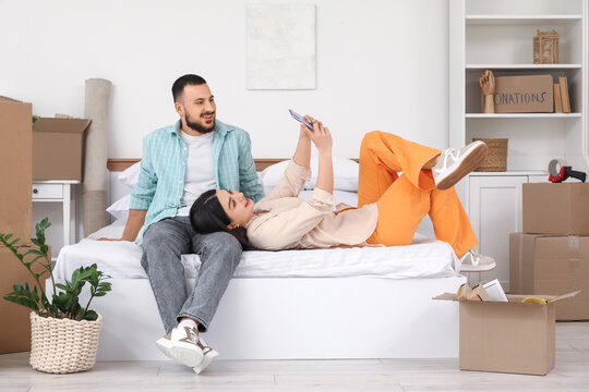 Happy young couple taking selfie in bedroom on moving day