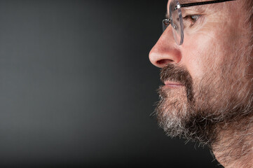 Portrait of  senior bearded man in eyeglasses on a black background