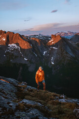 Man traveler hiking in sunset mountains travel solo in Norway active adventure trip, tourist climbing healthy lifestyle extreme vacations mountaineering tour