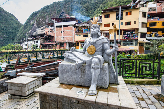 An inca king statue on the sidewalk by the river in Aguas Calientes, Peru