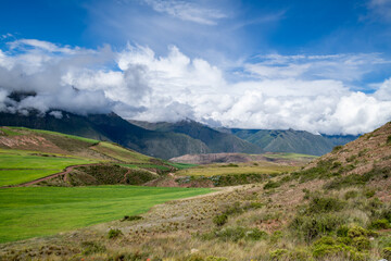 View of the Andes mountains in sacred valley, Peru with fog after a rain storm and clouds clearing up