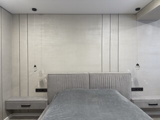Modern minimalist bedroom design with gray headboard and pendant lights
