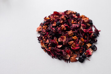 Red karkade tea with fruit slices and candied fruit. A bunch of dry leaves and berries. Fruit tea...