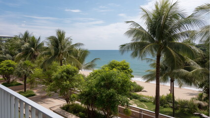 Landscape of a sunny beach, view from the balcony of a luxurious resort in the tropic. The fence of the balcony partially visible.