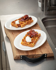 Two prepared portions of savory waffles with beef briskets and cheese