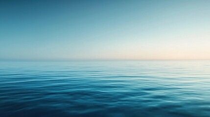 Obraz premium A tranquil expanse of the ocean fills the view, where soft waves lap at the surface under a dawn sky. The serene colors blend harmoniously, signaling the start of a new day