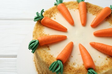 Delicious homemade carrot cake on white wooden table, closeup