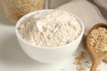 Brown rice and flour on white table, closeup
