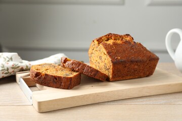 Cut homemade carrot cake with nuts on wooden table, closeup