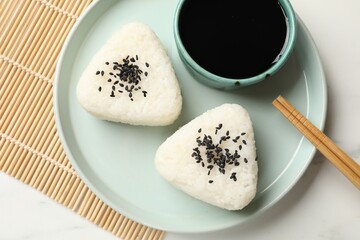 Rice balls (onigiri) served on light table, top view. Traditional Japanese dish