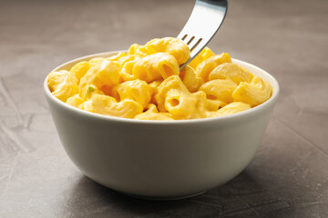 Taking delicious pasta with cheese sauce at grey table, closeup