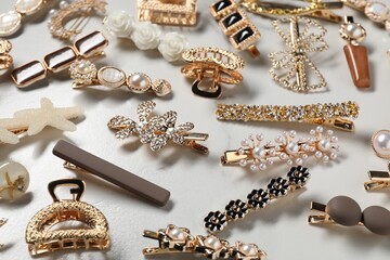 Beautiful hair clips on white marble table, above view