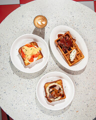 Flat lay of served table with brunch toasts and waffle with coffee
