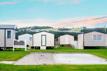 Obraz premium Cozy holiday homes nestled in a scenic location with lush greenery and serene sky during twilight hours