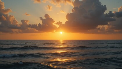 Obraz premium A vibrant orange sunset paints the sky over the tranquil sea, its light reflecting on the gentle waves near the beach