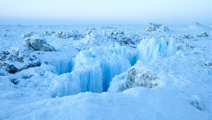 Explore a mystical frozen landscape shimmering ice formations deep blue crevasses and glistening frosted rocks under the dramatic arctic sun