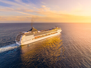 Cruise ship sailing at sunset with vibrant sky colors