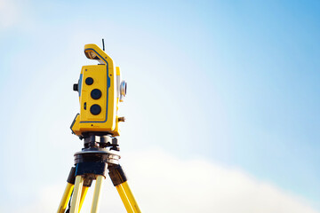 Surveying equipment positioned on  tripod under clear blue sky showcasing precision and technology...