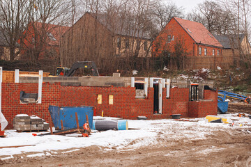 Construction site with brick walls and building materials in winter
