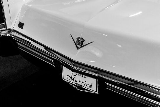 Limassol, Cyprus- December 19, 2024: Classic Cadillac Deville back element logo closeup with "Just Married" plate decorated for wedding use displayed at Cyprus Motor Museum in black and white