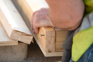 Close-up of Joiner making wooden shutter formwork nailing timber together