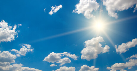 Bright sun on beautiful blue sky with white clouds.