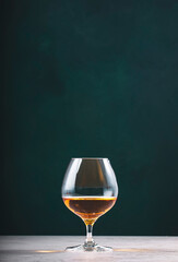 French cognac Superior in snifter glass on dark green background