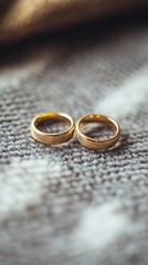 Beautiful close up shot of golden rings lying on grey carpet with blurred background.