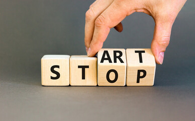 Start or stop symbol. Concept words Start or Stop on beautiful wooden block. Beautiful grey table...
