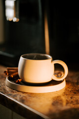Cup of coffee resting on a warm countertop in a cozy kitchen during morning light