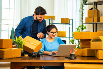 Small Indian business partners handling garment packaging and laptop inventory entry