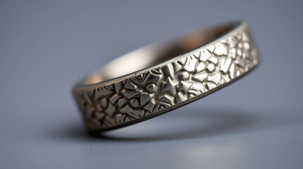 Intricate metal ring with floral patterns showcased on a plain background