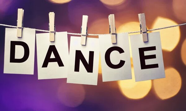 The word "DANCE" is spelled out on individual cards held up by clothespins.
