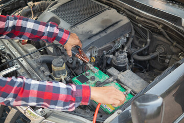 The man is checking the engine and condition of car to fix it properly and safely before traveling...