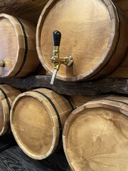 wooden wine barrels with brass taps in rustic cellar - traditional oak aging for vineyard production