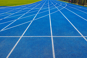 Blue running track at the city stadium, next to white markings. Intersection of marking lines.