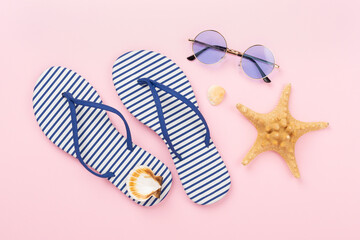 Striped blue flip flops with accessories on color background, top view