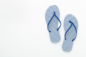 Striped blue flip flops on color background, top view