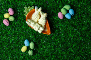 Colorful Easter candy bunnies and eggs arranged on vibrant green grass